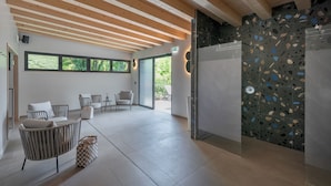 A modern interior with a kitchen area, seating arrangement, and a view of greenery outside. - Hotel Royal Village (Limone sul Garda)
