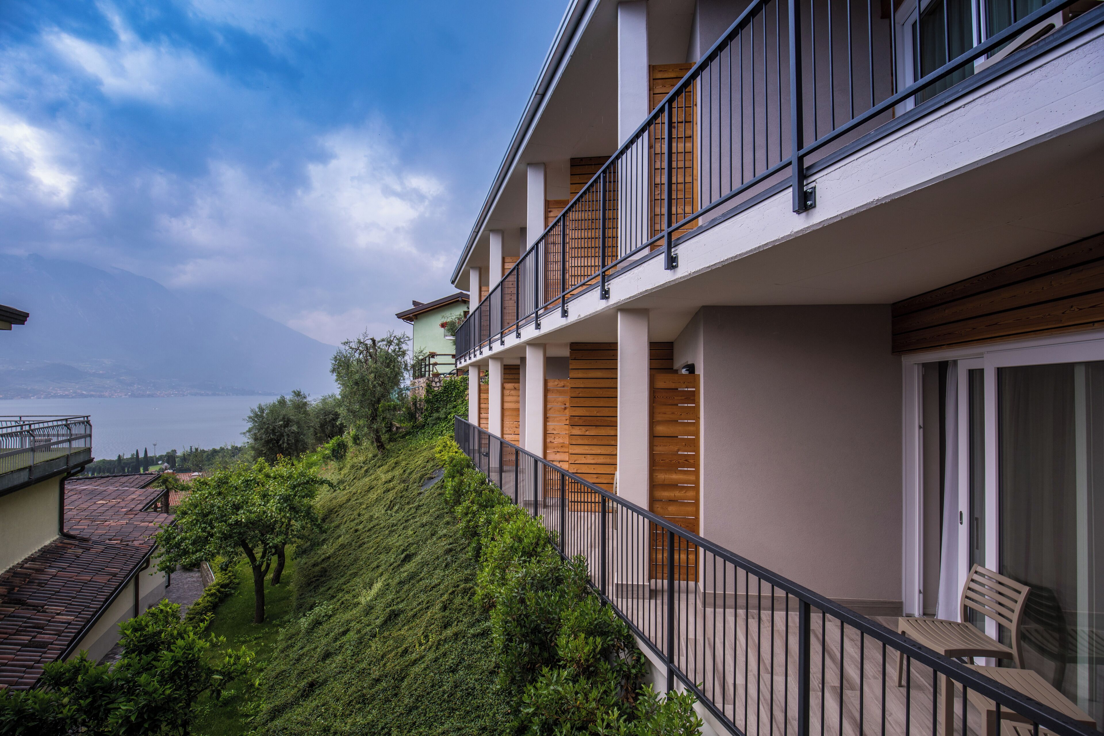 Un immeuble à plusieurs étages doté de balcons, de rampes en bois et offrant une vue sur une étendue d’eau.