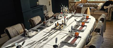 A conference room with a long table set for a meeting, equipped with nameplates, notepads, and coffee cups.