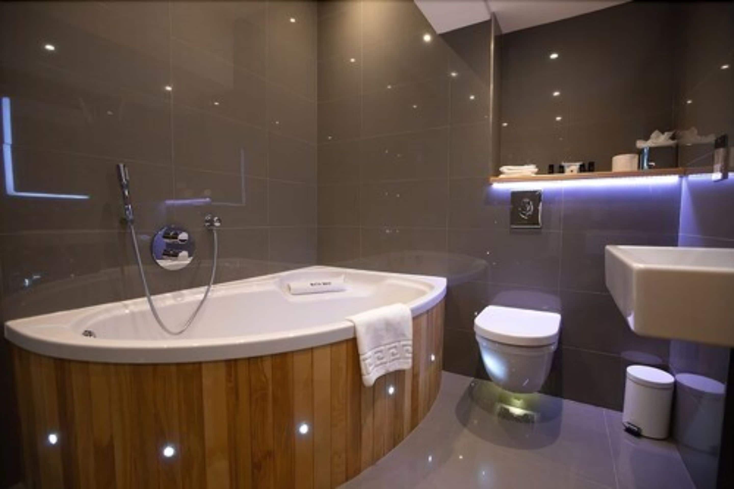 A modern bathroom with a freestanding bathtub, a toilet, and a sink.