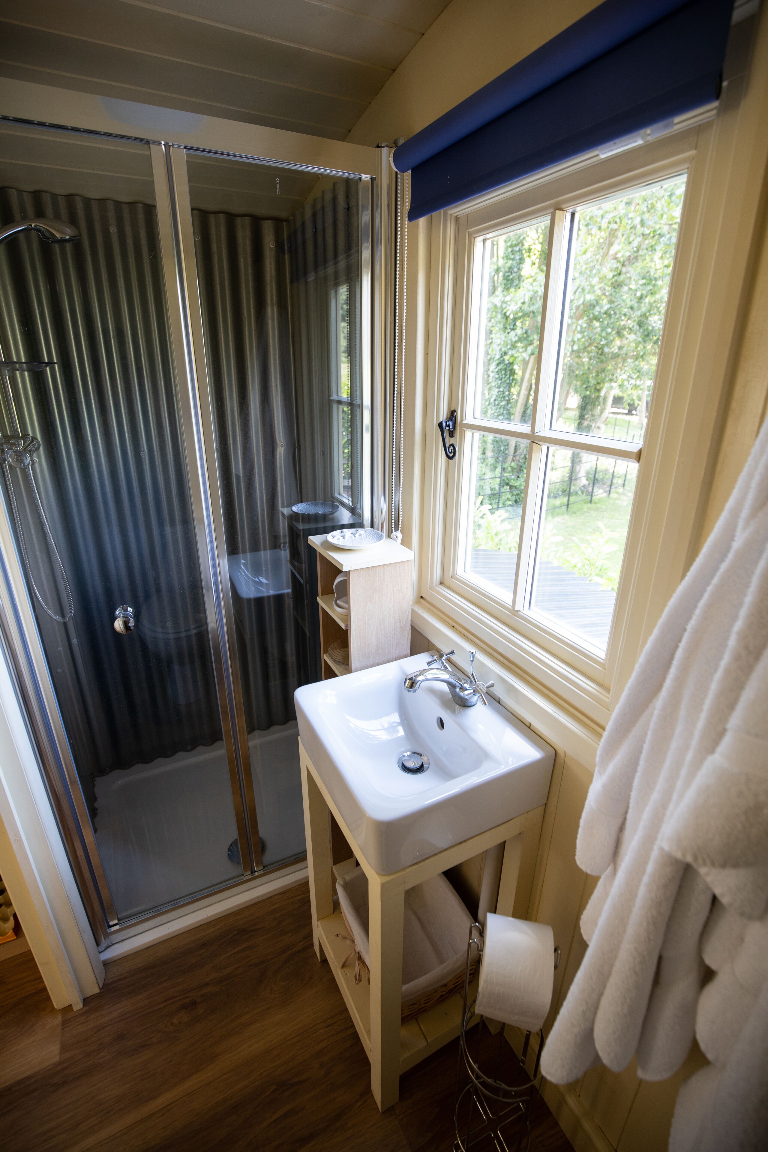 A bathroom with a shower, sink, and window.