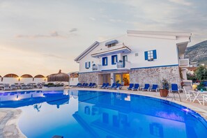 A resort with a swimming pool, lounge chairs, and a building with a white facade and blue accents. - Monta Verde Hotel and Villas - Boutique Class (Fethiye)