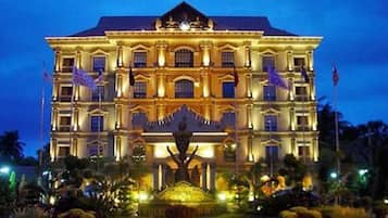 A large, multi-story building with a symmetrical facade, multiple balconies, and a central entrance.