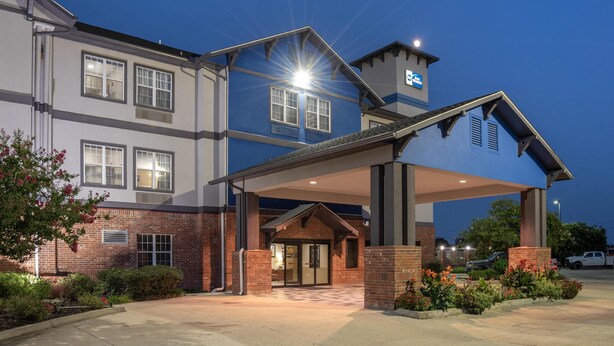 A multi-story hotel with a covered entrance and brick facade.