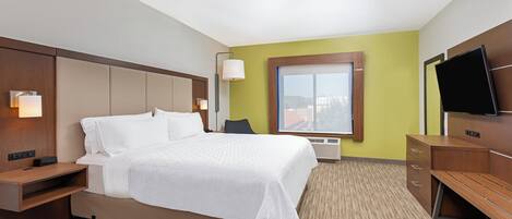 A hotel room with a bed, bedside tables, a TV, a window, and a wall-mounted lamp.