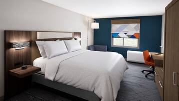 A modern hotel room with a large bed, a desk, and a chair.