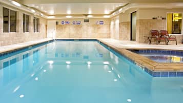 Una piscina techada, sillones reclinables de piscina