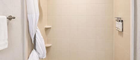 A bathroom with a bathtub, a showerhead, and a towel rack.