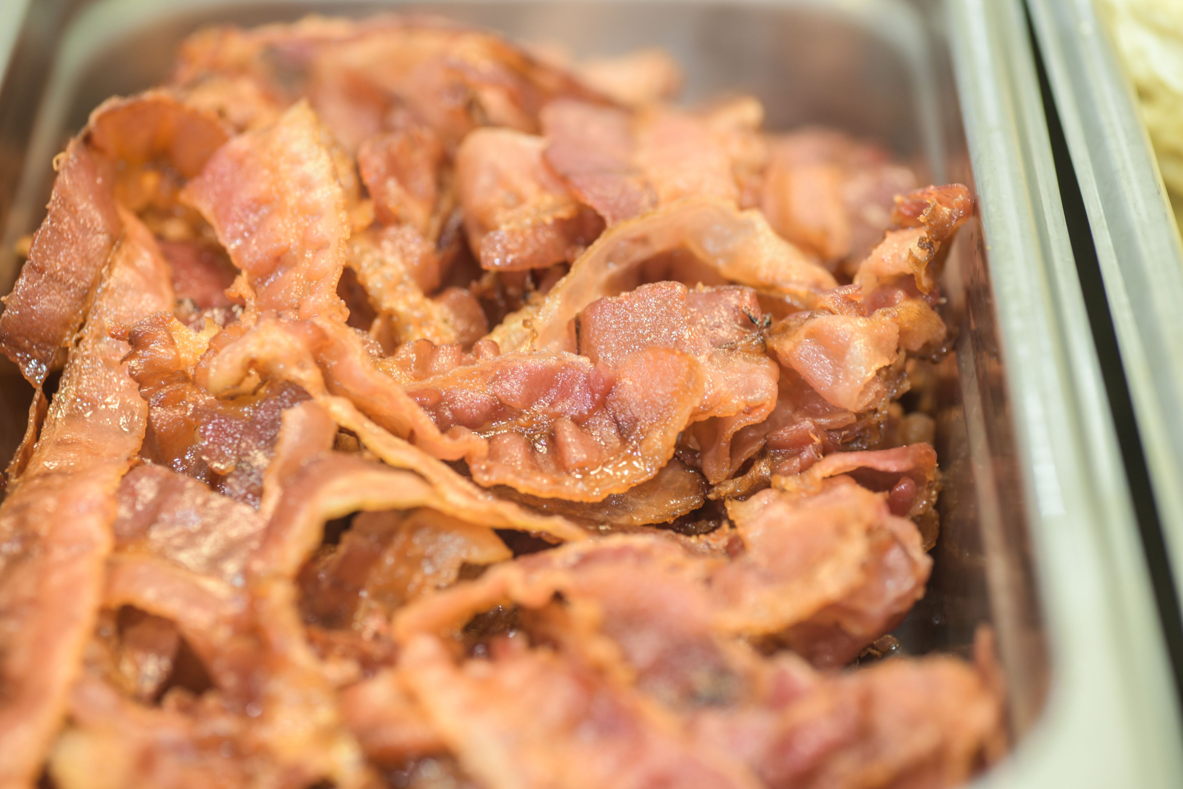 A close-up of cooked bacon strips in a container.