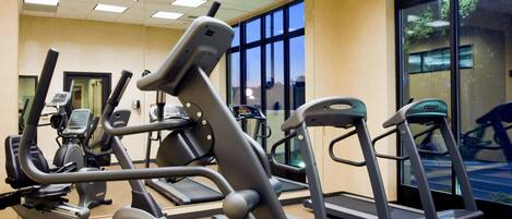 A fitness center with treadmills, elliptical machines, and stationary bikes.