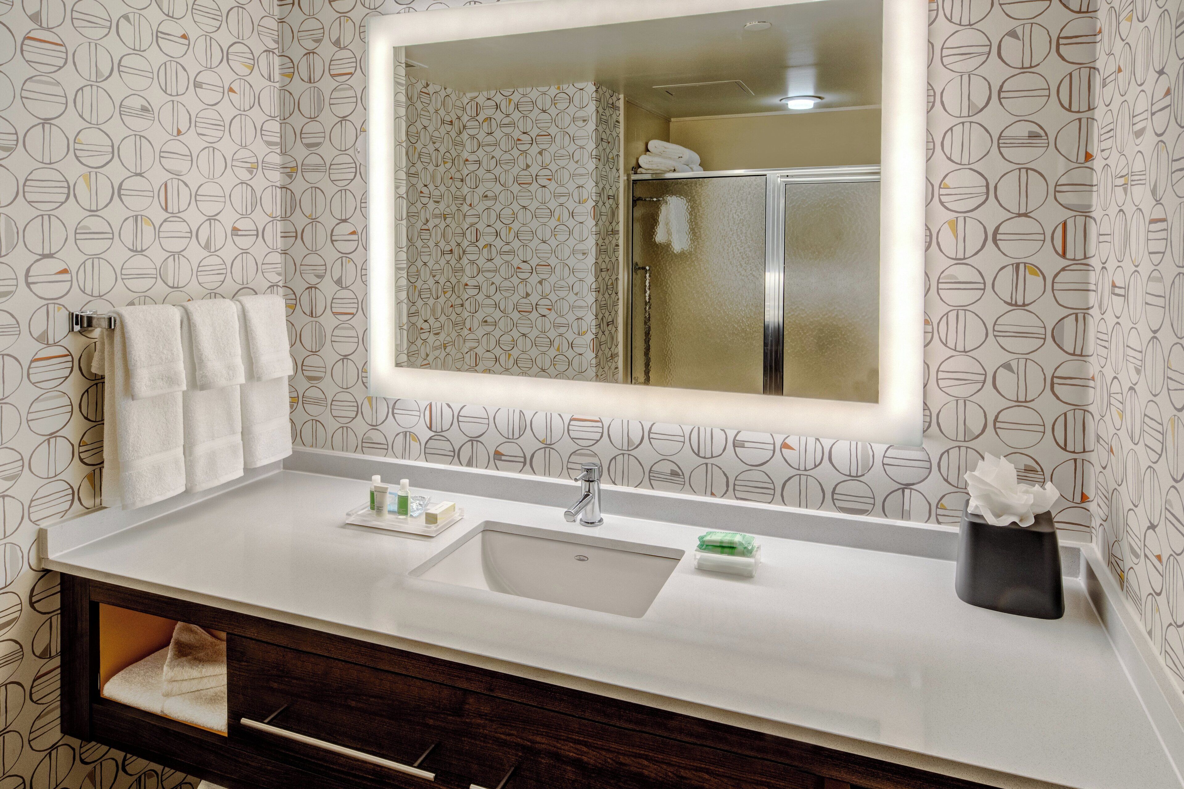 A bathroom with a white sink, a mirror, and a towel rack.