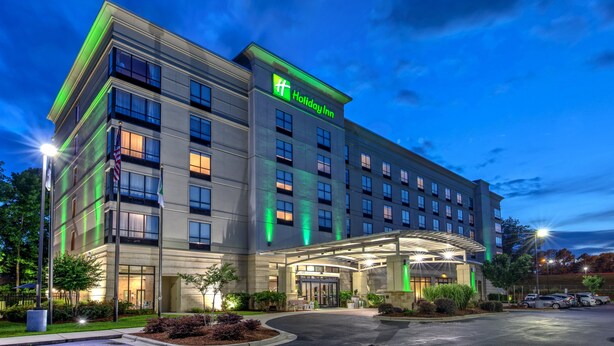 Un hotel Holiday Inn dal design moderno, caratterizzato da un ampio ingresso e numerosi piani.
