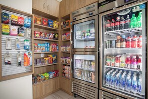A self-service beverage and snack area with various brands of sodas, energy drinks, and snacks.