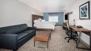 A hotel room with a bed, a sofa, a desk, and a TV. - Holiday Inn Express & Suites Chowchilla - Yosemite Park Area by IHG (Chowchilla)