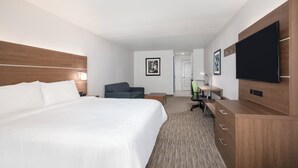 A hotel room with a large bed, a desk, a chair, a TV, and a wardrobe. - Holiday Inn Express & Suites Chowchilla - Yosemite Park Area by IHG (Chowchilla)