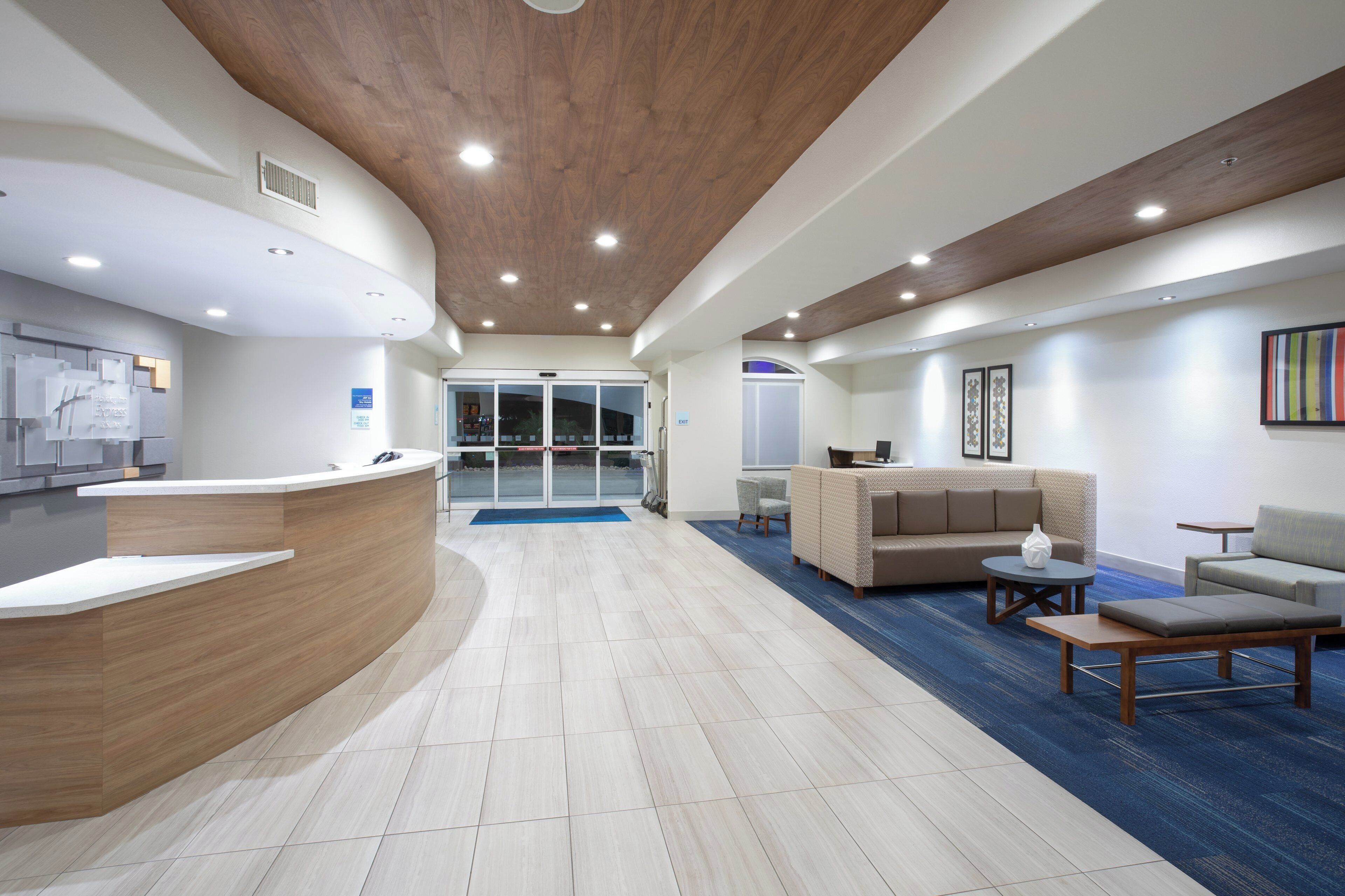 A reception area with a curved reception desk, a waiting area with a sofa and chairs, and a reception desk with a computer.