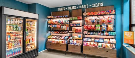 Zona de exhibición de bocadillos con bebidas refrigeradas y una variedad de snacks empaquetados.