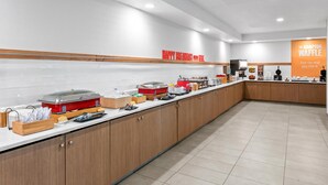 A modern breakfast buffet with a sign reading 'HAPPY BREAKFAST' and 'THE HAMPTON WAFFLE'. - Hampton Inn & Suites National Harbor - Alexandria Area (Oxon Hill)