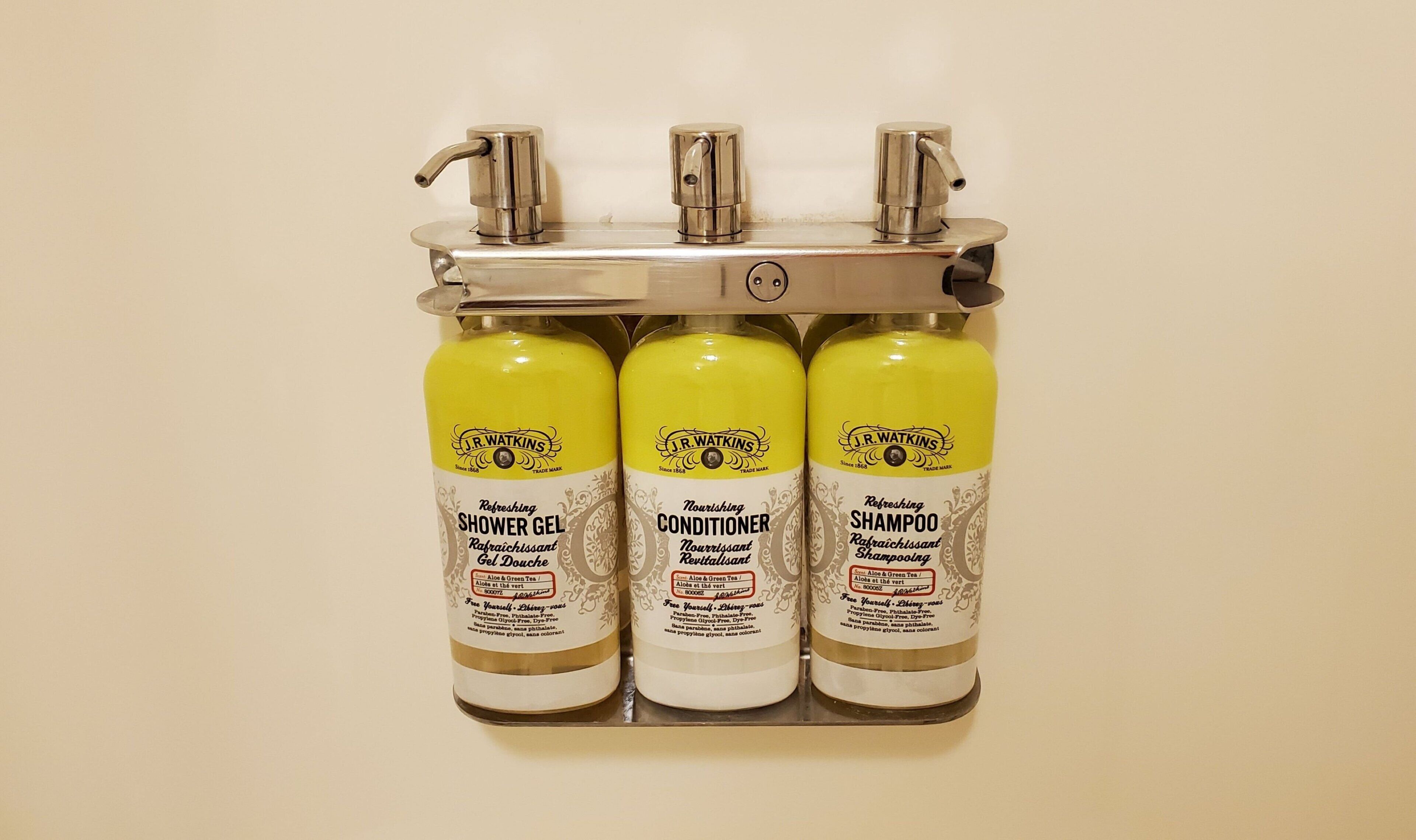 Drie J.R. Watkins producten: douchegel, conditioner en shampoo, gepresenteerd op een metalen plank.