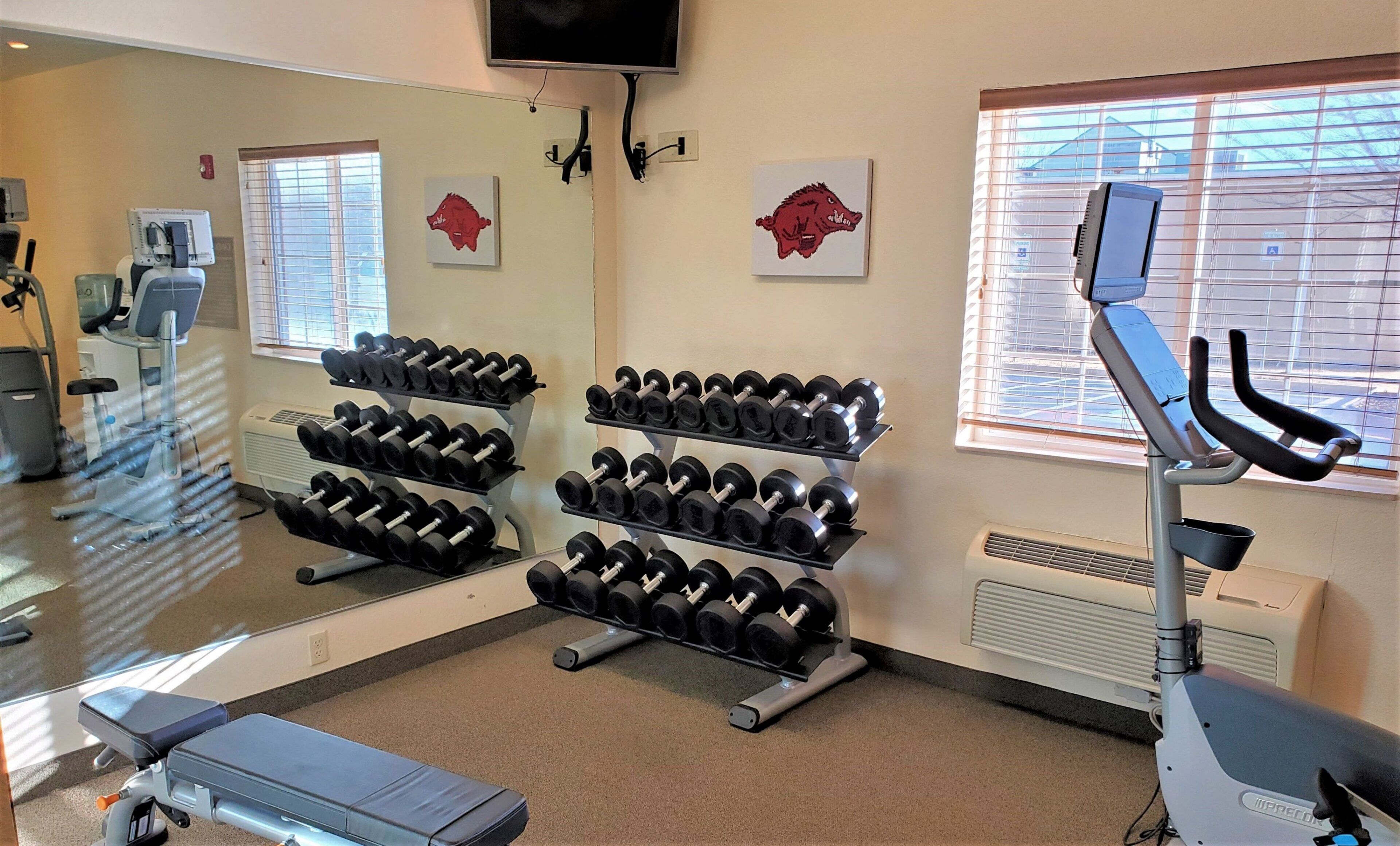 A gym with exercise equipment, including dumbbells and a stationary bike.