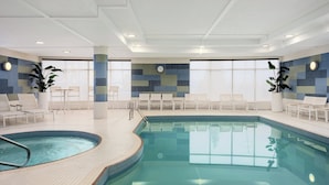 An indoor swimming pool with tiled walls, lounge chairs, and a clock on the wall. - Holiday Inn Express & Suites Vaughan-Southwest by IHG (Vaughan)