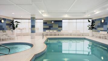 Una piscina techada, sillones reclinables de piscina