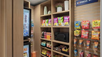 A self-service snack area with various packaged snacks and a microwave.