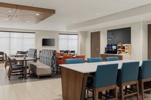 A modern hotel dining area with tables and chairs, a coffee station, and a large window. - Holiday Inn Express & Suites Vaughan-Southwest by IHG (Vaughan)