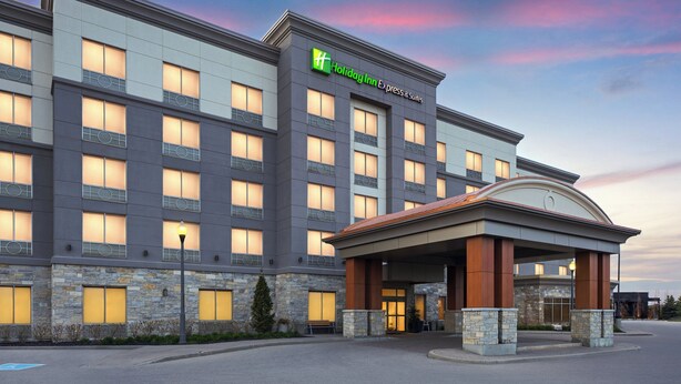 A Holiday Inn Express & Suites building with a stone facade, large windows, and a covered entrance. - Holiday Inn Express & Suites Vaughan-Southwest by IHG (Vaughan)