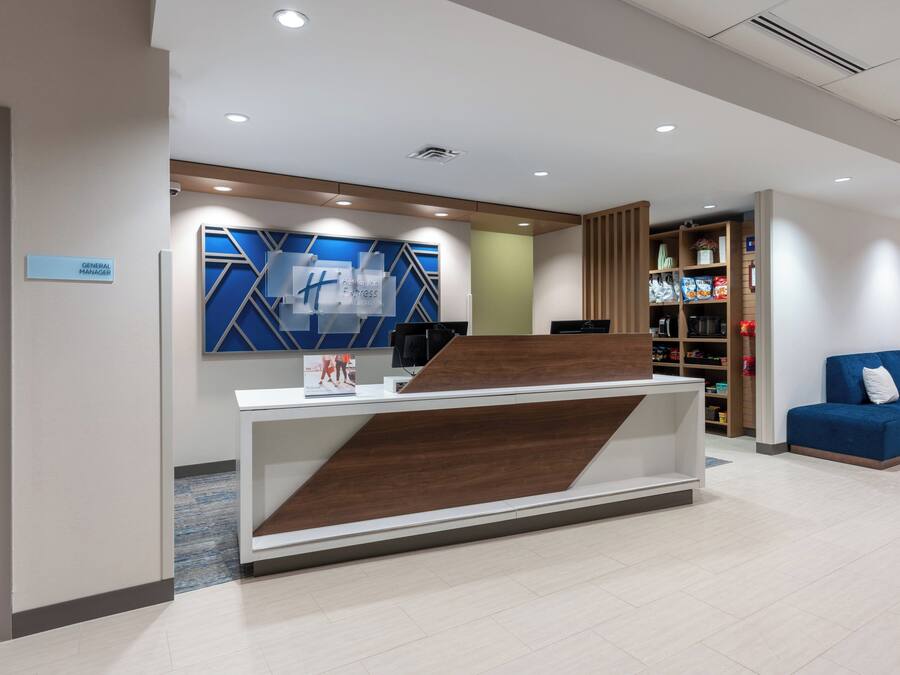 Una recepción con diseño moderno, una pared azul con motivos geométricos y un sofá azul al fondo.