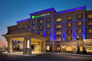 Un hotel Holiday Inn Express & Suites con entrada cubierta, varios pisos y fachada bien iluminada.