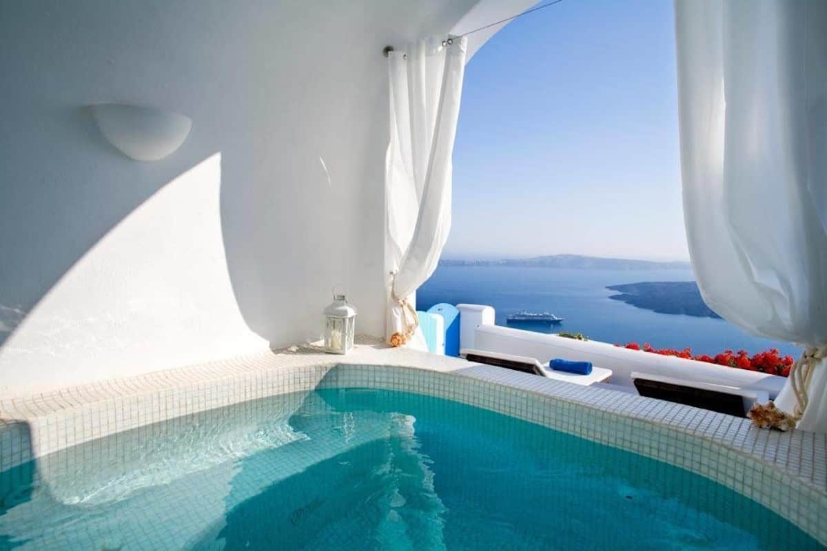A clear view of a swimming pool with a view of the sea and a white building.