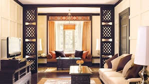A well-lit living room with a sofa, a coffee table, and a television.