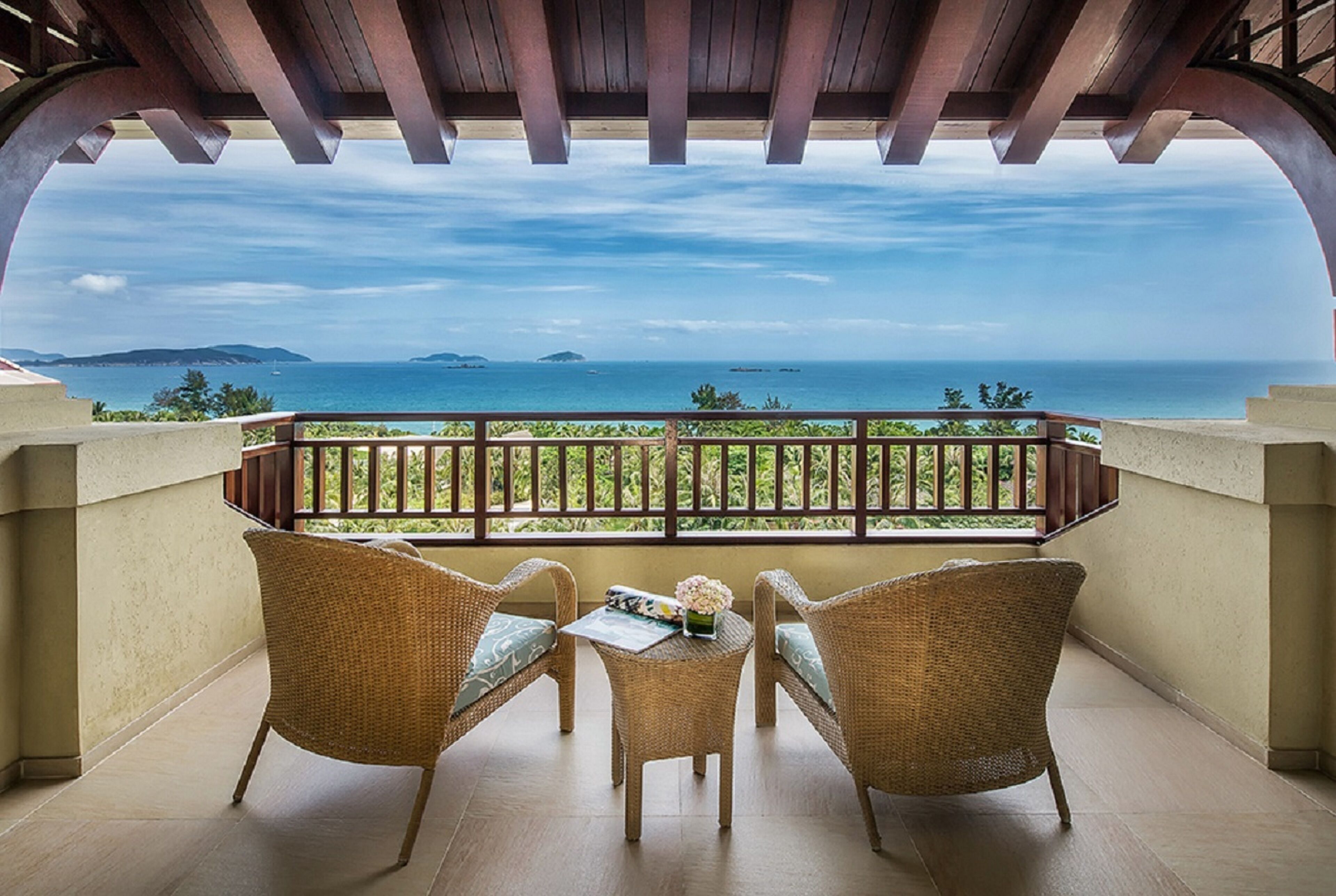 A balcony with wicker furniture and a view of the sea.
