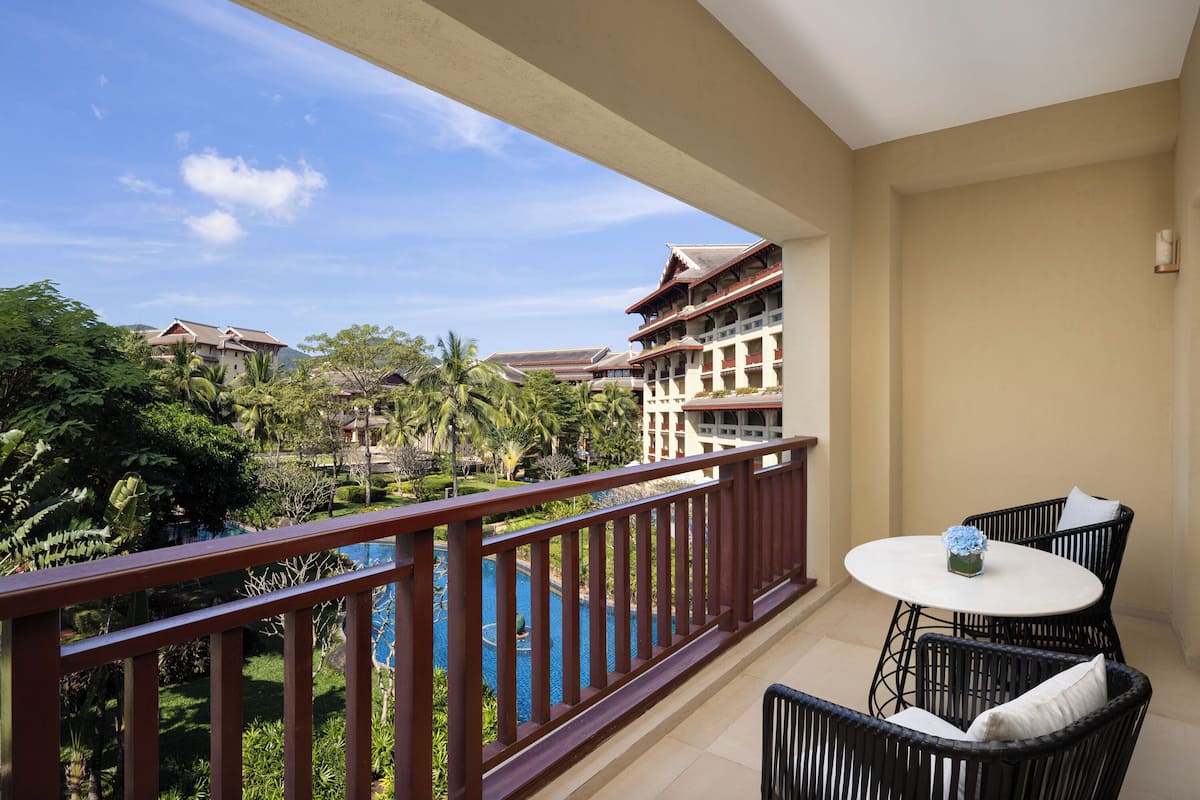 A balcony with a view of a swimming pool and hotel buildings.