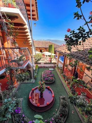 A courtyard with a central water feature, surrounded by potted plants and a seating area. - Hotel La Casa de Mama (San Cristóbal de las Casas)