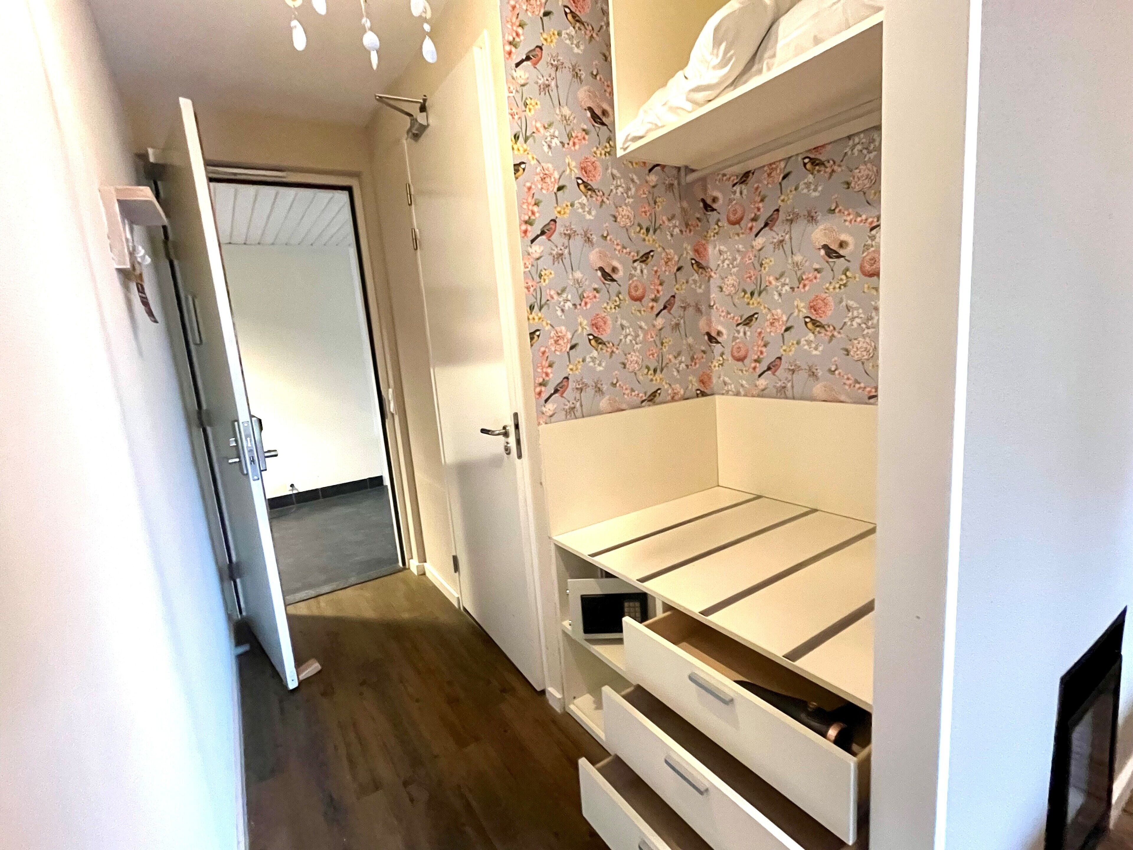 Un dormitorio con cama, armario y puerta que da a otra habitación.