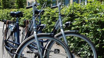 Two bicycles parked on a paved surface with a building in the background.