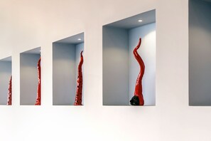 Una serie de esculturas rojas en nichos blancos.