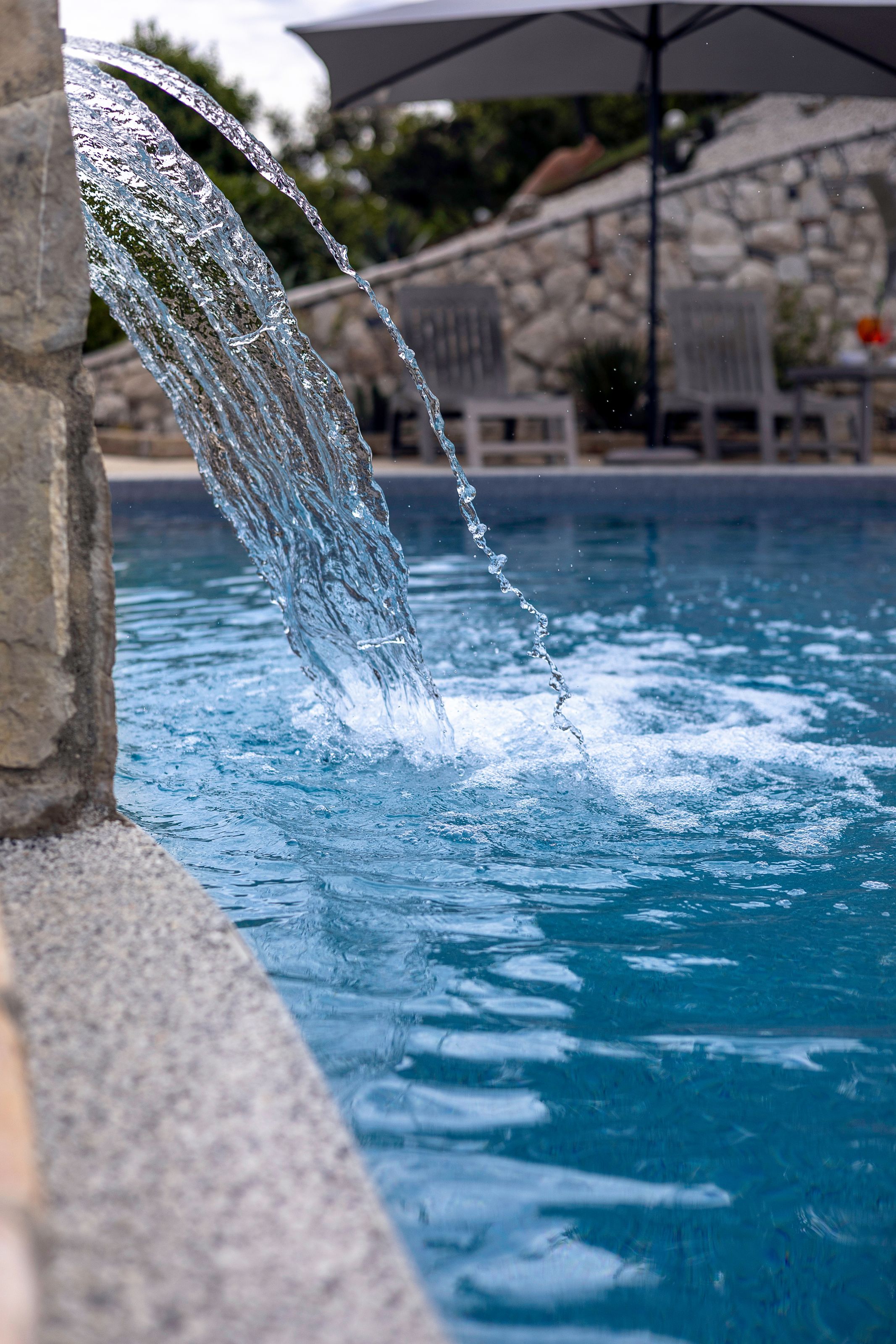 Una piscina con agua cristalina y una cascada.