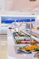 Una mesa de buffet con diversos alimentos y utensilios.