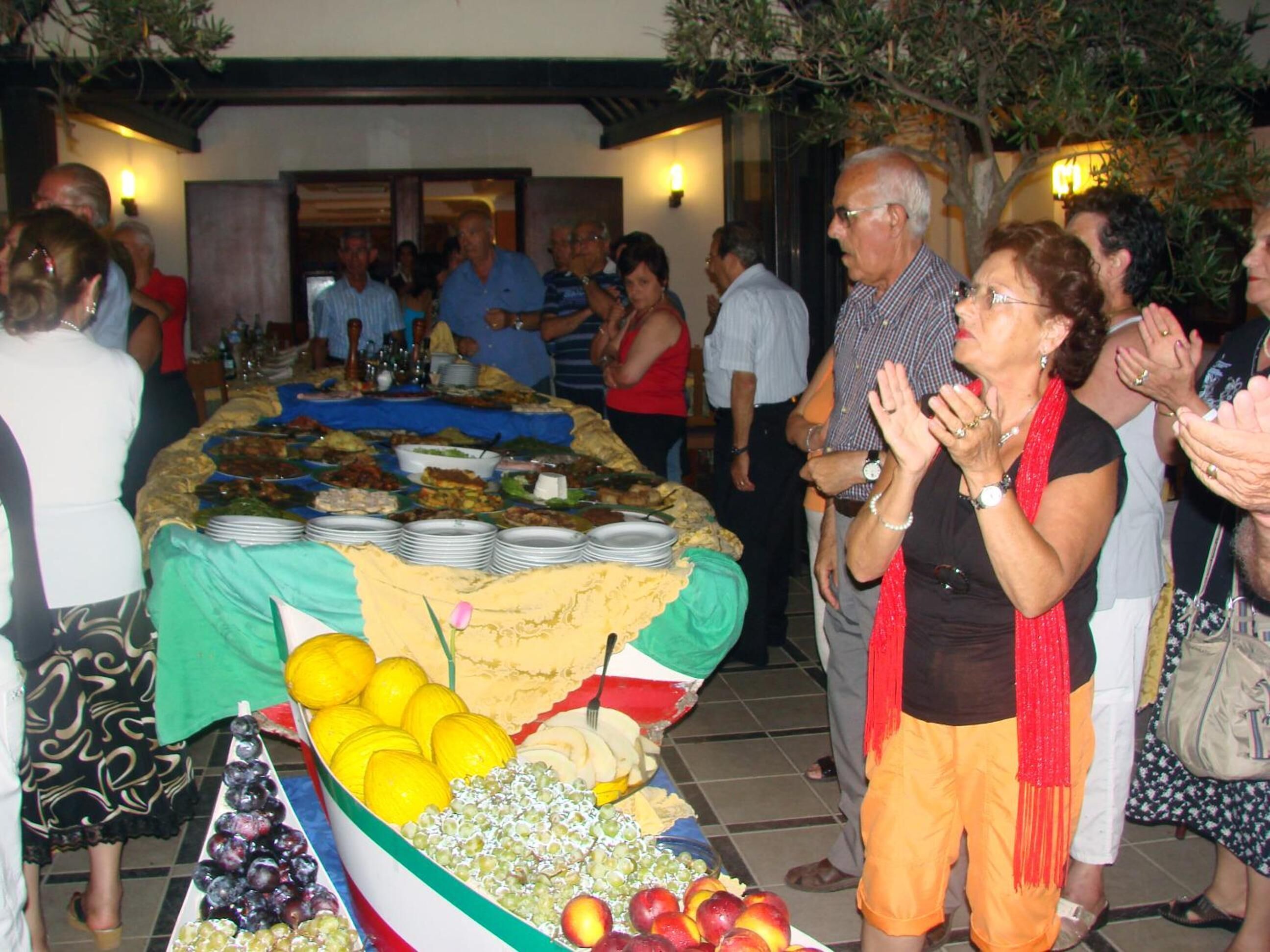 A buffet with various dishes and fruits.