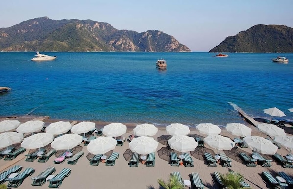 Playa privada, camastros, sombrillas y bar en la playa