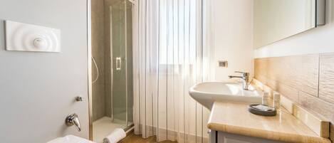 Un baño moderno con ducha, inodoro y lavamanos.