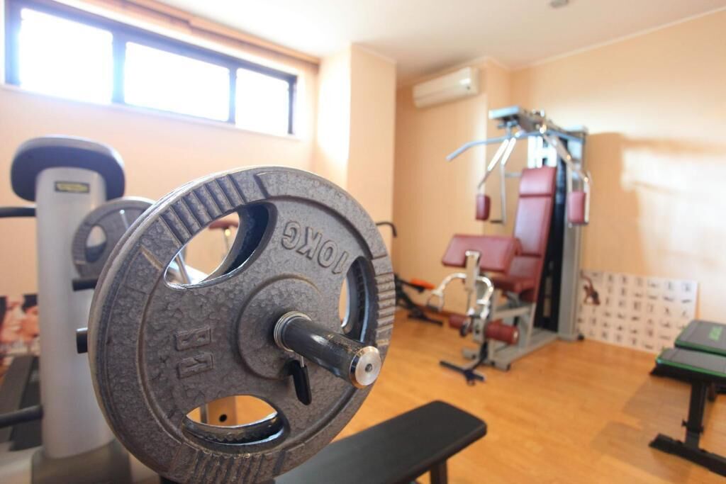 A weightlifting bench with a weight plate in a gym.