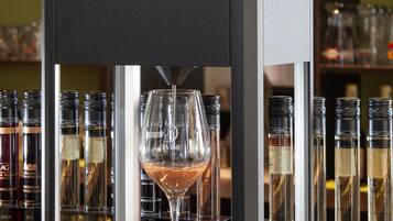 Un distributeur de vin D-VINE avec un verre à vin placé devant.