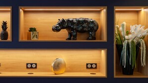 Una pared con tres estantes de madera que exhiben varios objetos decorativos.