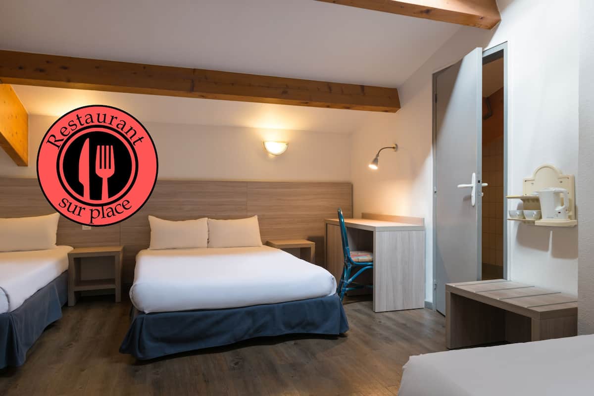 A hotel room with a bed, two bedside tables, a desk, a chair, and a small table.
