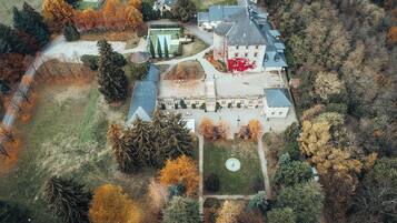 An aerial view of a large estate with multiple buildings, a central courtyard, and surrounding trees.