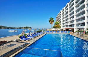 Una piscina al aire libre, sombrillas, tumbonas
